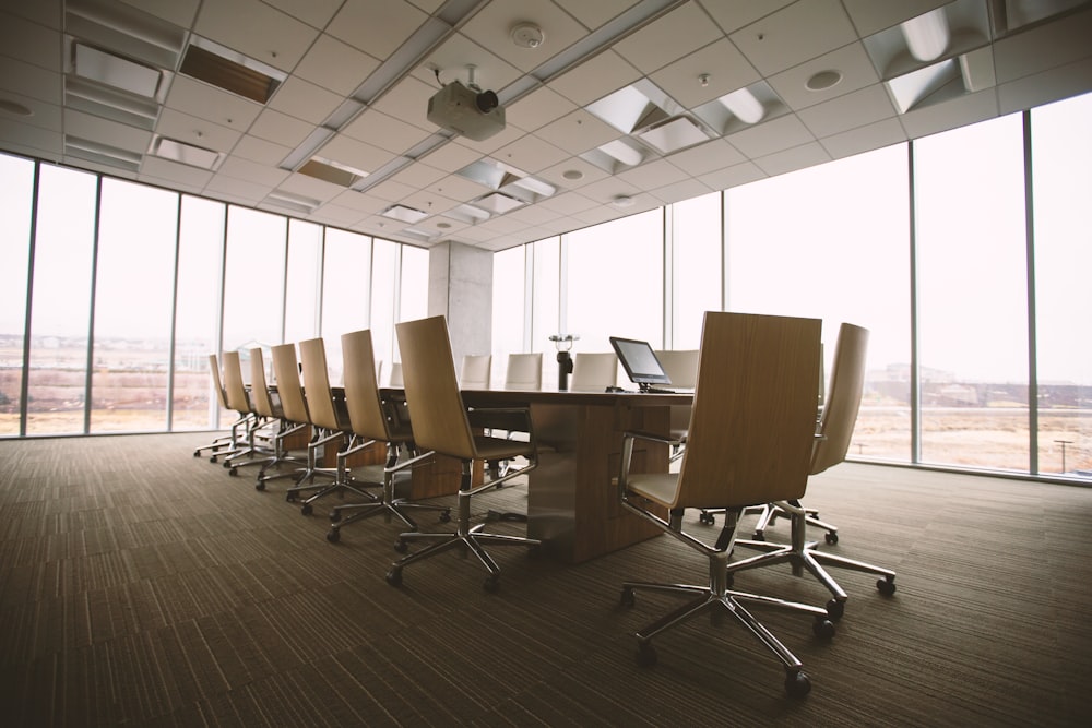 An empty boardroom with chairs along a long table